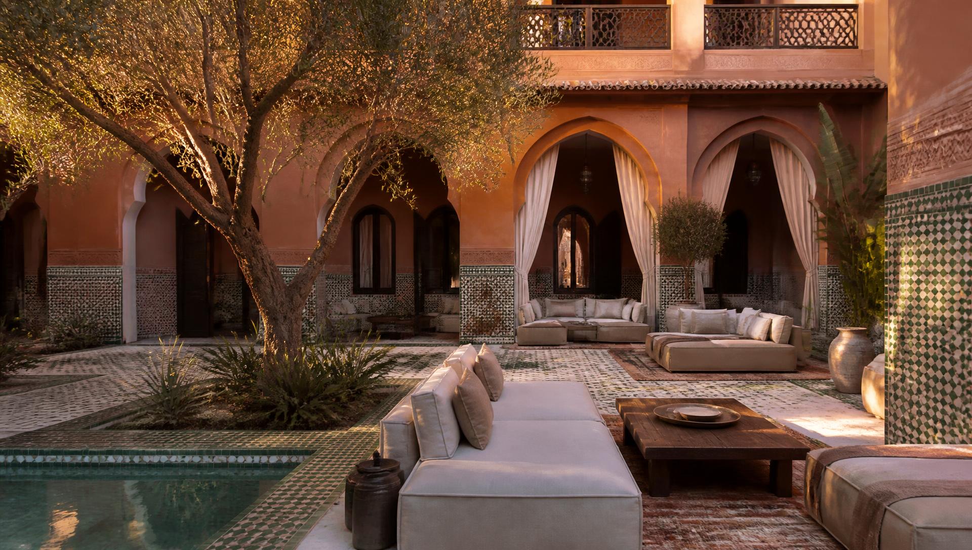 Binnenplaats van een riad in Marrakech met olijfboom, zellige-tegels en zitbanken