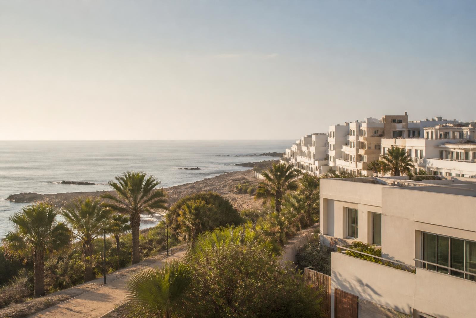 Lichte appartementen aan de Marokkaanse Atlantische kust met palmen en zee